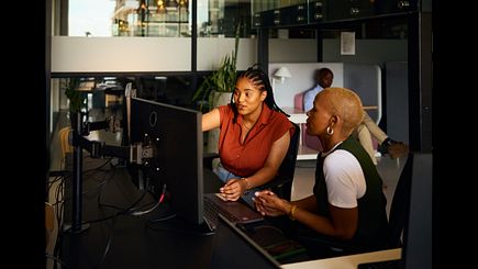 Computer programmers collaborating on software development project in modern office