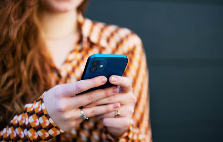 Close up of a woman using her smart phone to check her social media accounts.
