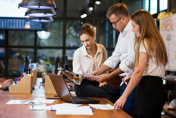 Product Development Team is reviewing a new product and business plan during a meeting in an office.