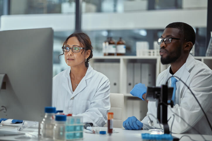 Two scientists working together on a computer in a lab.