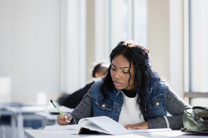 Black female college student concentrates on studying math textbooks for her upcoming exam.